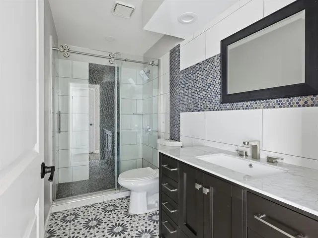 a bathroom with a sink a toilet and shower