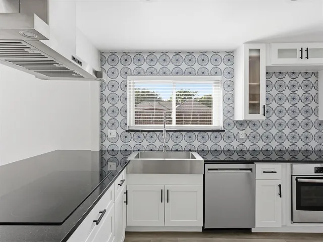 a kitchen with granite countertop a sink and a stove