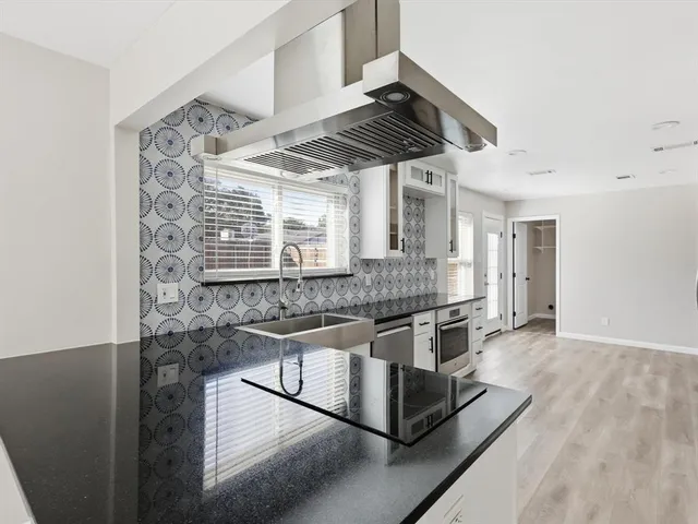 a kitchen with stainless steel appliances granite countertop a stove and a sink