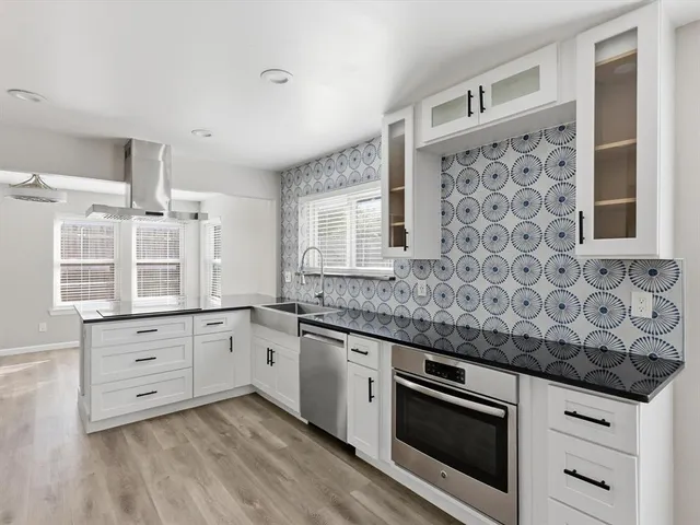 a kitchen with granite countertop white cabinets and white appliances