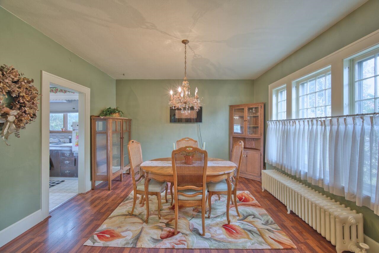 701 Grant Avenue Eveleth, MN 55734 - Photo 11 of 50 Dining room with radiator, plenty of natural light, a chandelier, and wood finished floors