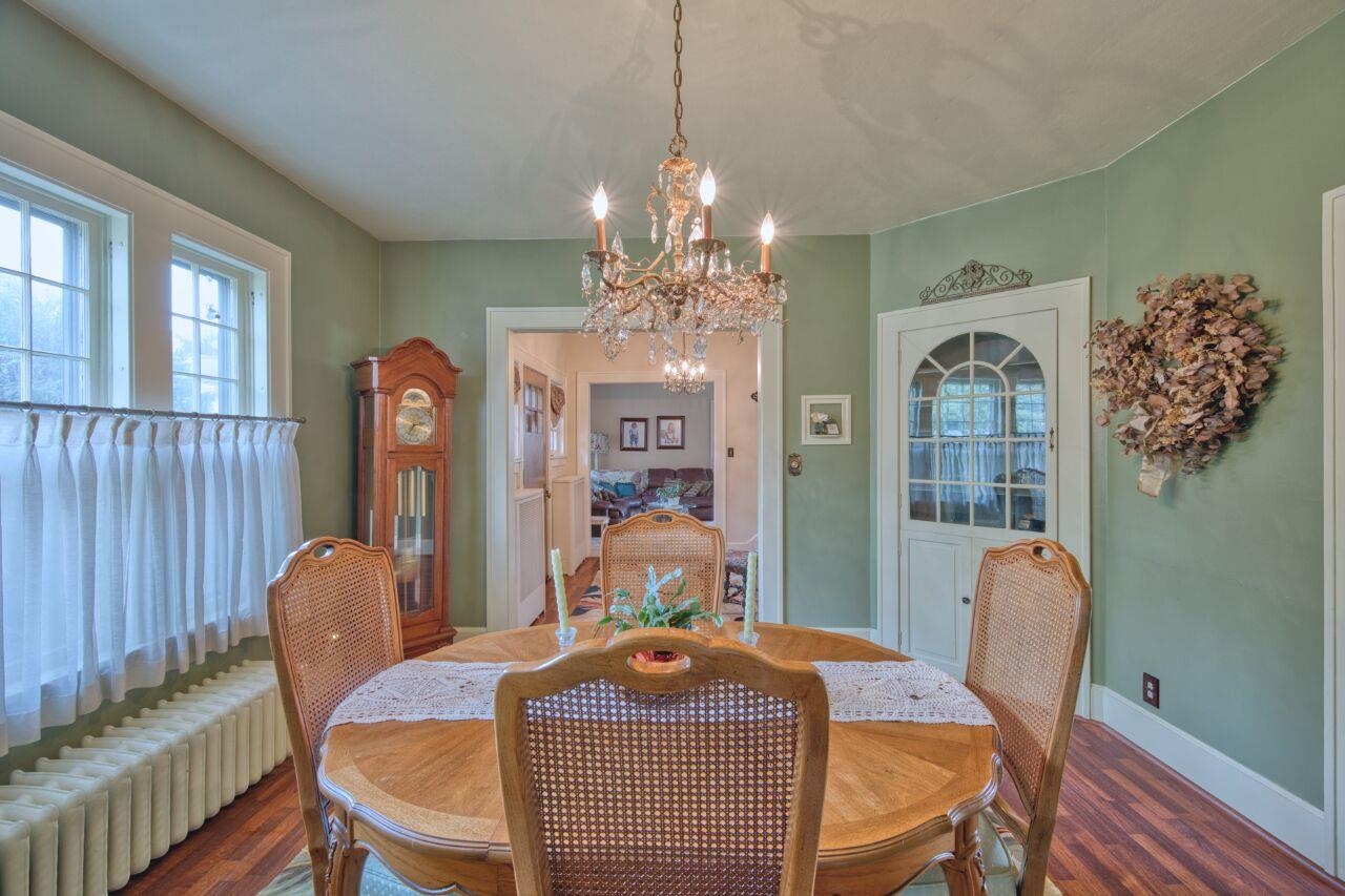 701 Grant Avenue Eveleth, MN 55734 - Photo 12 of 50 Dining room with wood finished floors, radiator heating unit, healthy amount of natural light, and a chandelier