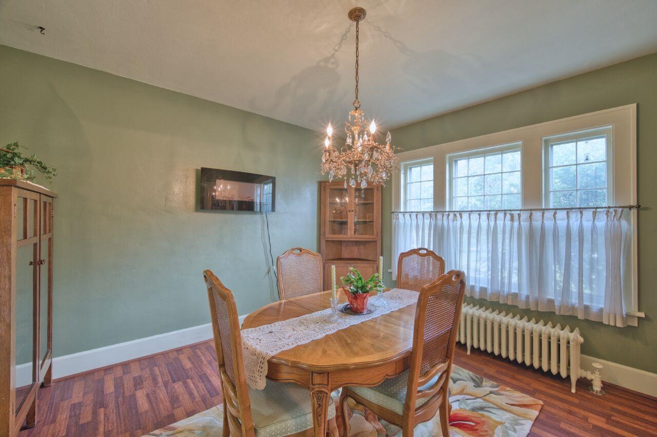 701 Grant Avenue Eveleth, MN 55734 - Photo 13 of 50 Dining room with radiator heating unit, a chandelier, and dark wood-style flooring