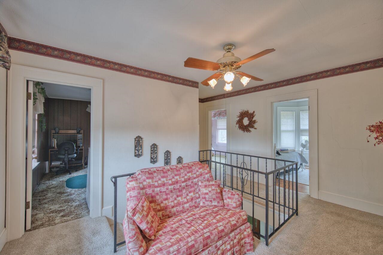 701 Grant Avenue Eveleth, MN 55734 - Photo 19 of 50 Sitting room featuring carpet floors, an upstairs landing, ornamental molding, a ceiling fan, and an office area