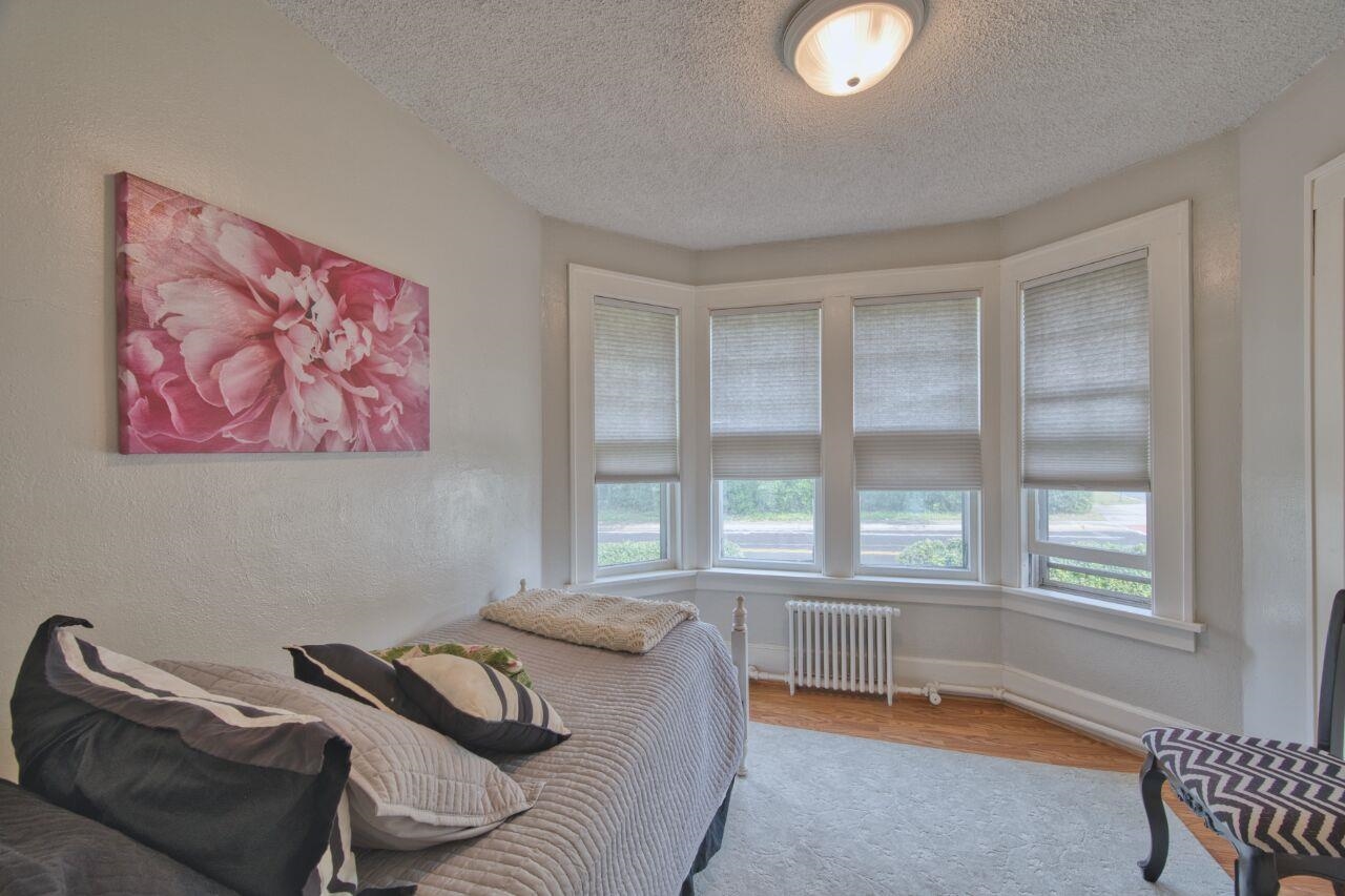 701 Grant Avenue Eveleth, MN 55734 - Photo 24 of 50 Bedroom featuring radiator, wood finished floors, a textured ceiling, and a textured wall
