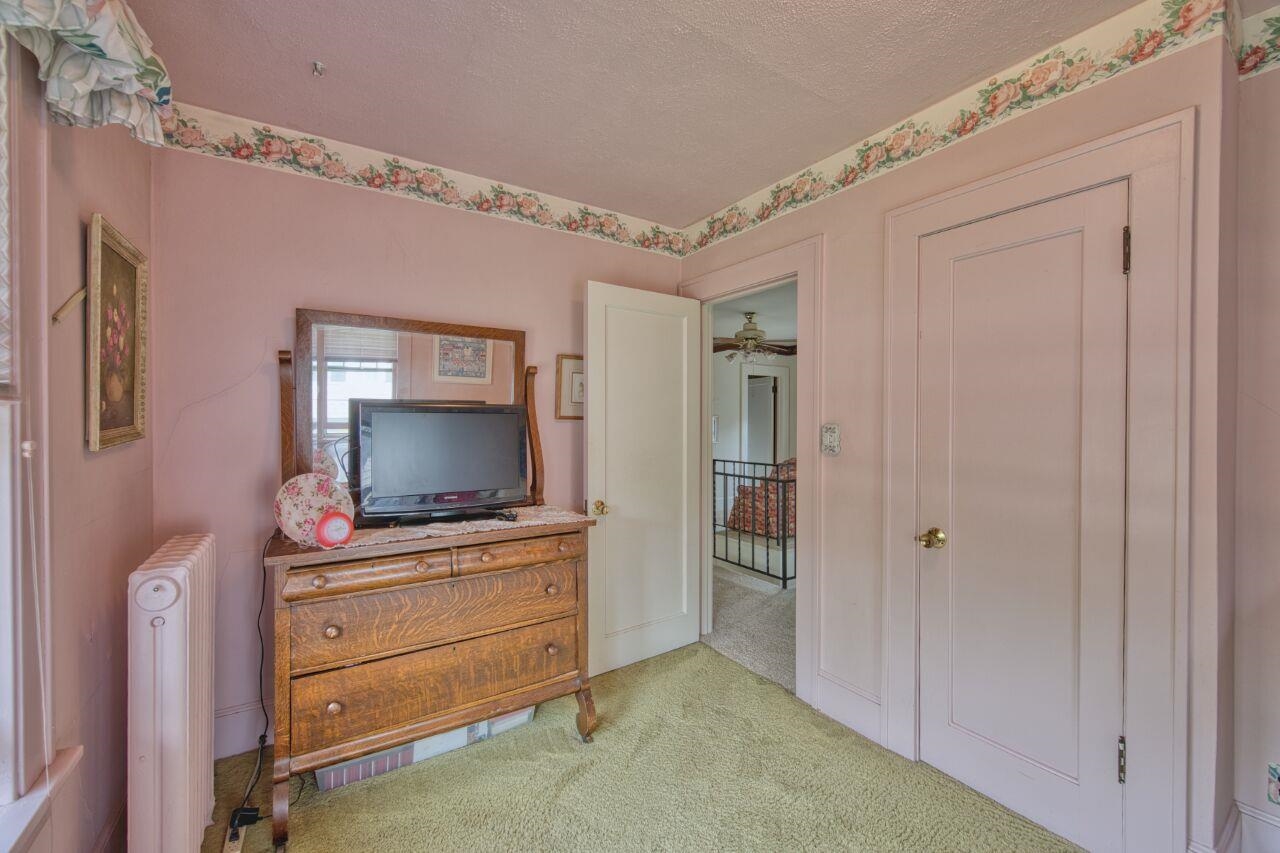 701 Grant Avenue Eveleth, MN 55734 - Photo 27 of 50 Bedroom with carpet flooring, radiator, and a textured ceiling