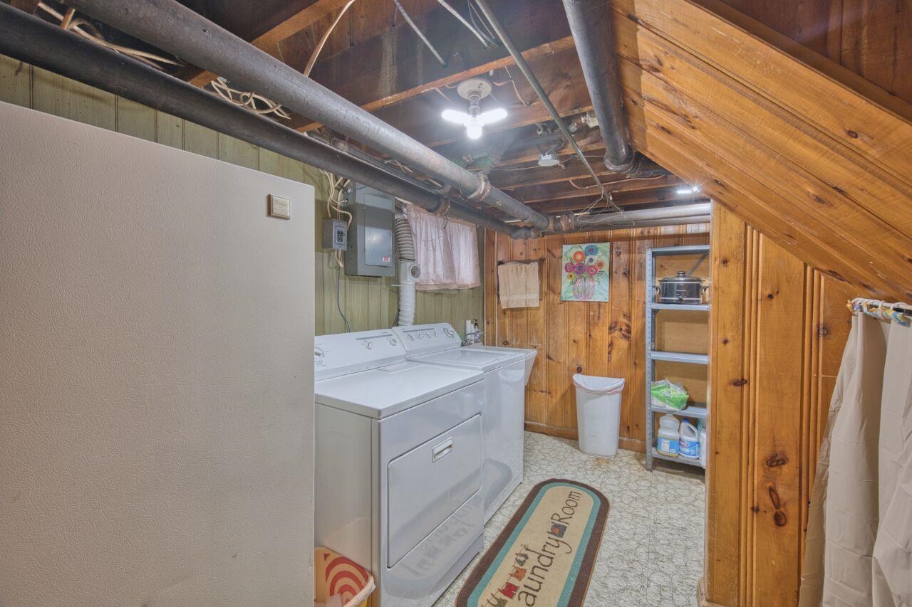 701 Grant Avenue Eveleth, MN 55734 - Photo 38 of 50 Washroom featuring wood walls, washer and dryer, electric panel, and light floors