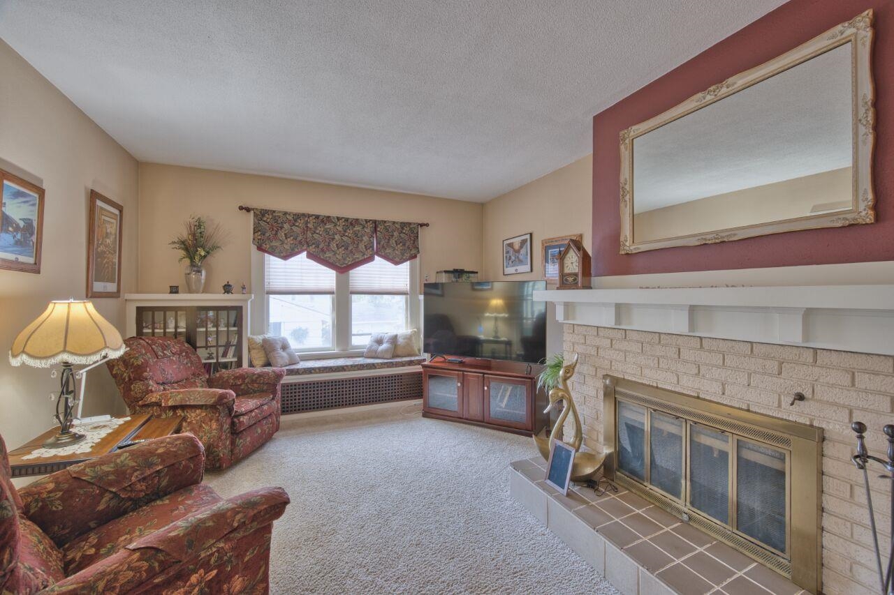 701 Grant Avenue Eveleth, MN 55734 - Photo 4 of 50 Living room featuring a brick fireplace, carpet, and a textured ceiling