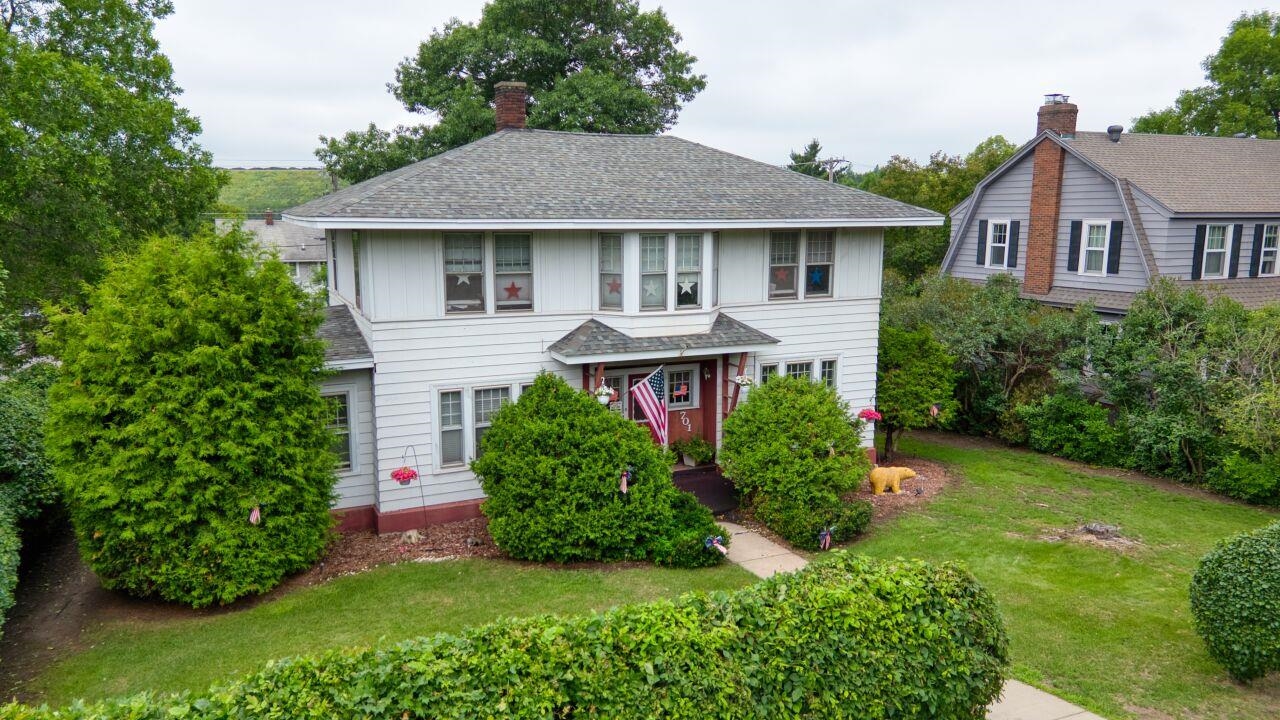 701 Grant Avenue Eveleth, MN 55734 - Photo 49 of 50 View of front facade featuring a front yard, a shingled roof, and a chimney