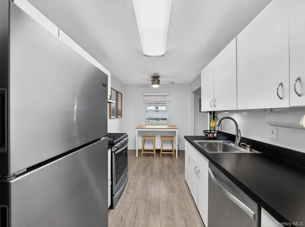 a kitchen with a sink a refrigerator and cabinets