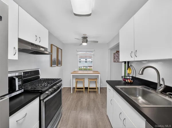 a kitchen with stainless steel appliances a sink a stove and cabinets