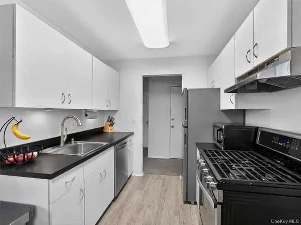 a kitchen with granite countertop a sink stove and cabinets