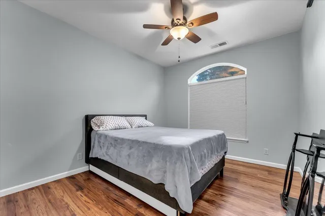 a kitchen with stainless steel appliances granite countertop a refrigerator a sink dishwasher a stove and a dining table with wooden floor