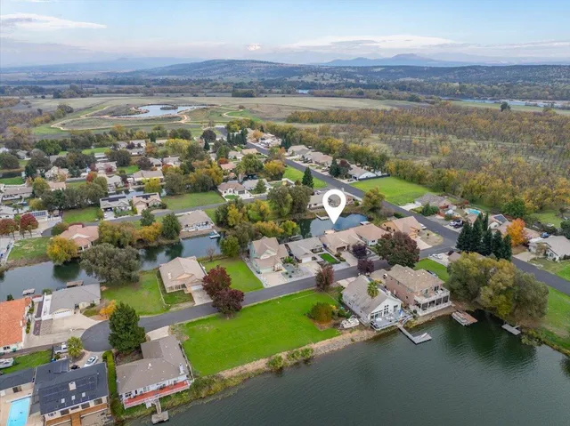 an aerial view of ocean and residential houses with outdoor space