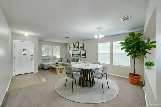 a view of a dining room with furniture and a potted plant