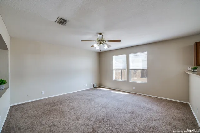 a view of a livingroom with a ceiling fan and window