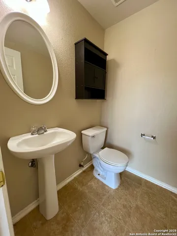 a bathroom with a sink a toilet and a mirror