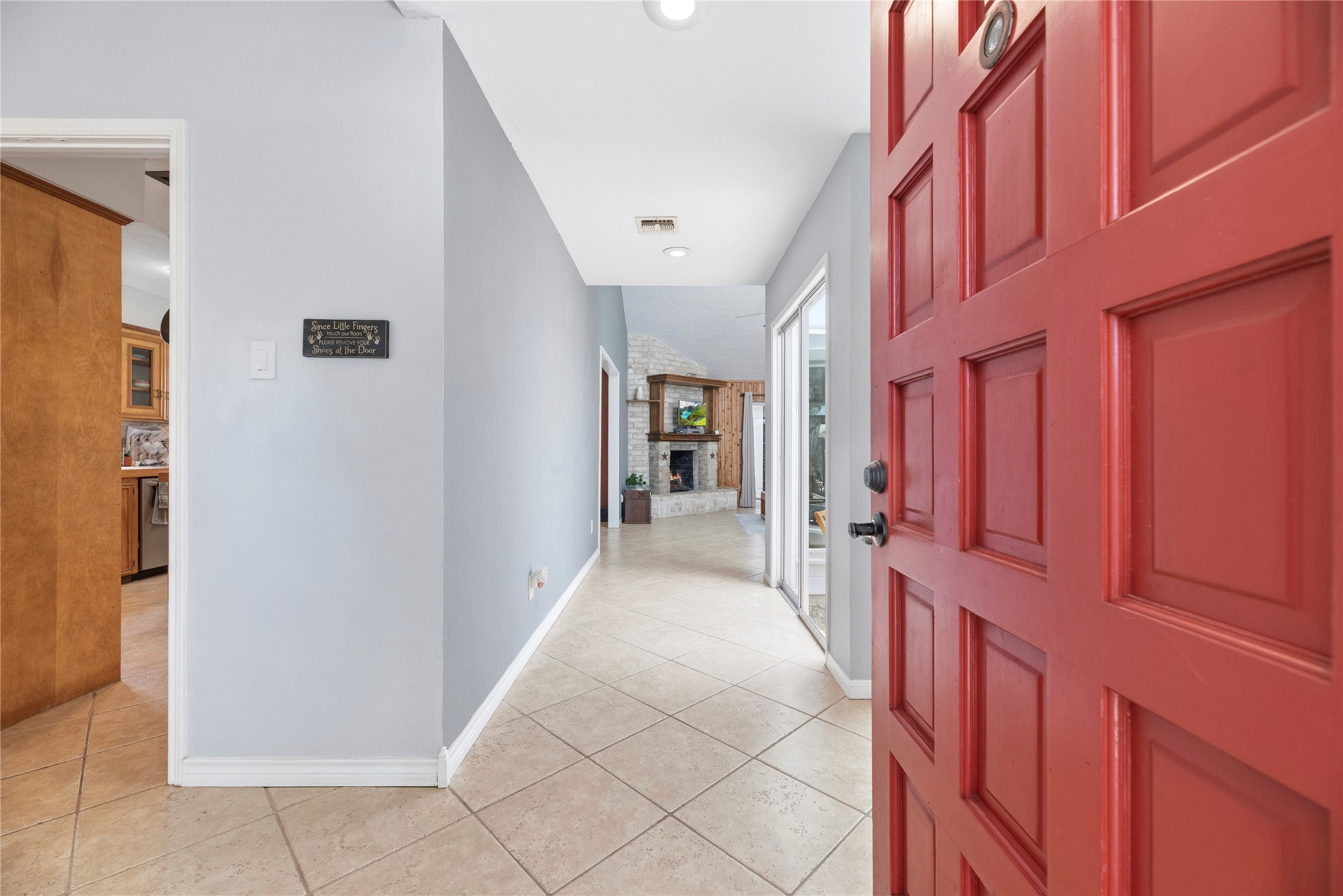 14203 Wickersham Lane Houston, TX 77077 - Photo 3 of 25 Entryway perspective showcasing the open-concept sightlines from the front door down the main tiled hallway, leading toward the spacious living room and the central open atrium.