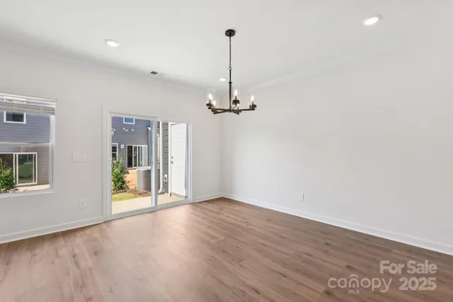 a view of empty room with wooden floor and ceiling fan