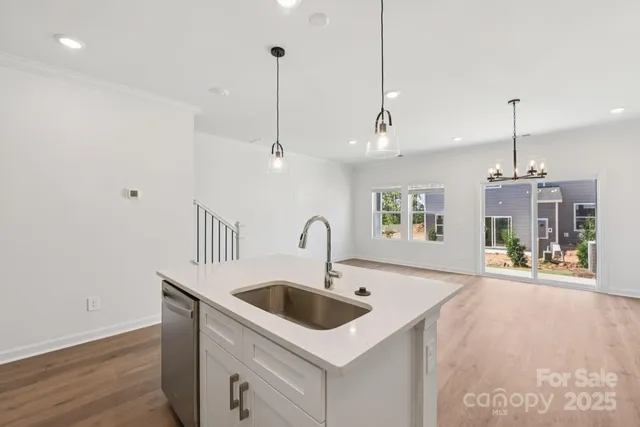 a kitchen with a sink a counter space and a chandelier