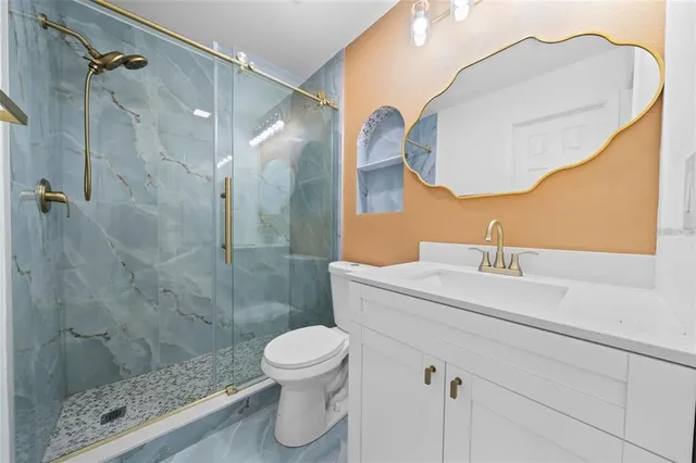 a bathroom with a sink a toilet and shower