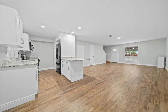 a view of kitchen with wooden floor and electronic appliances