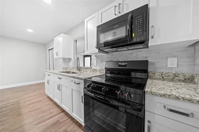 a kitchen with stainless steel appliances granite countertop a stove microwave and oven