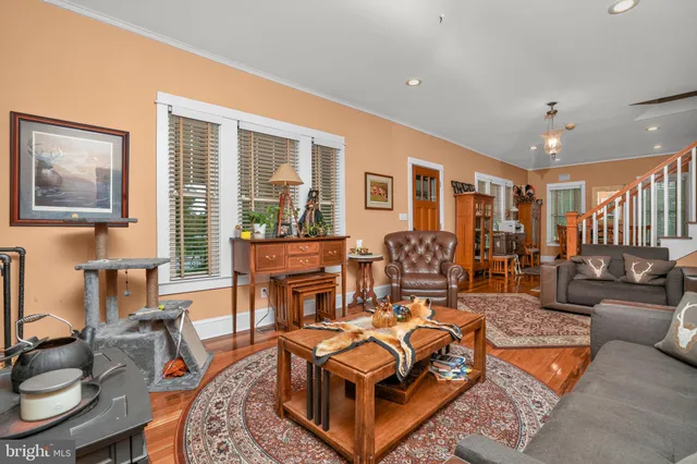 a kitchen with stainless steel appliances kitchen island granite countertop a table chairs and a wooden floor