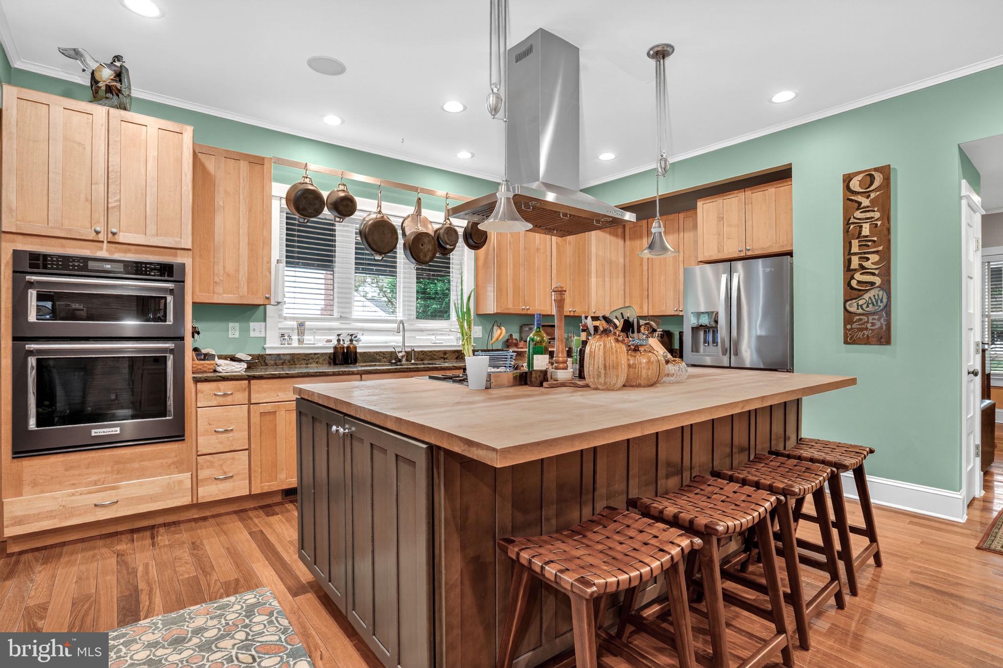 501 South Main Street Berlin, MD 21811 - Photo 17 of 75 a kitchen with stainless steel appliances granite countertop a table chairs and a refrigerator