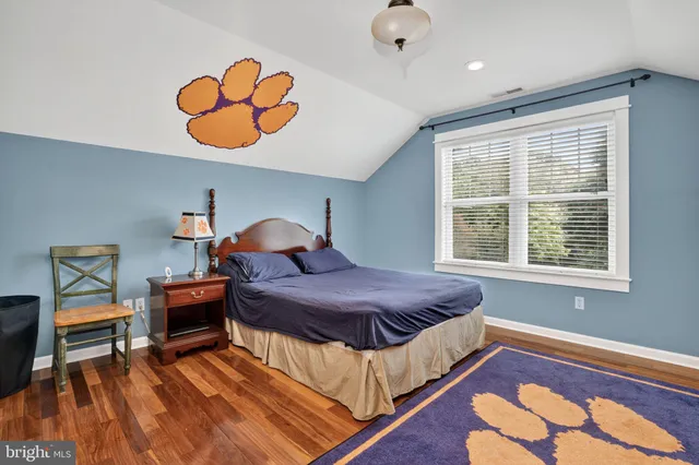 a bedroom with a bed and a flat tv screen on wall