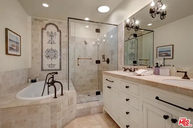 a bathroom with a bathtub sink double vanity and mirrors