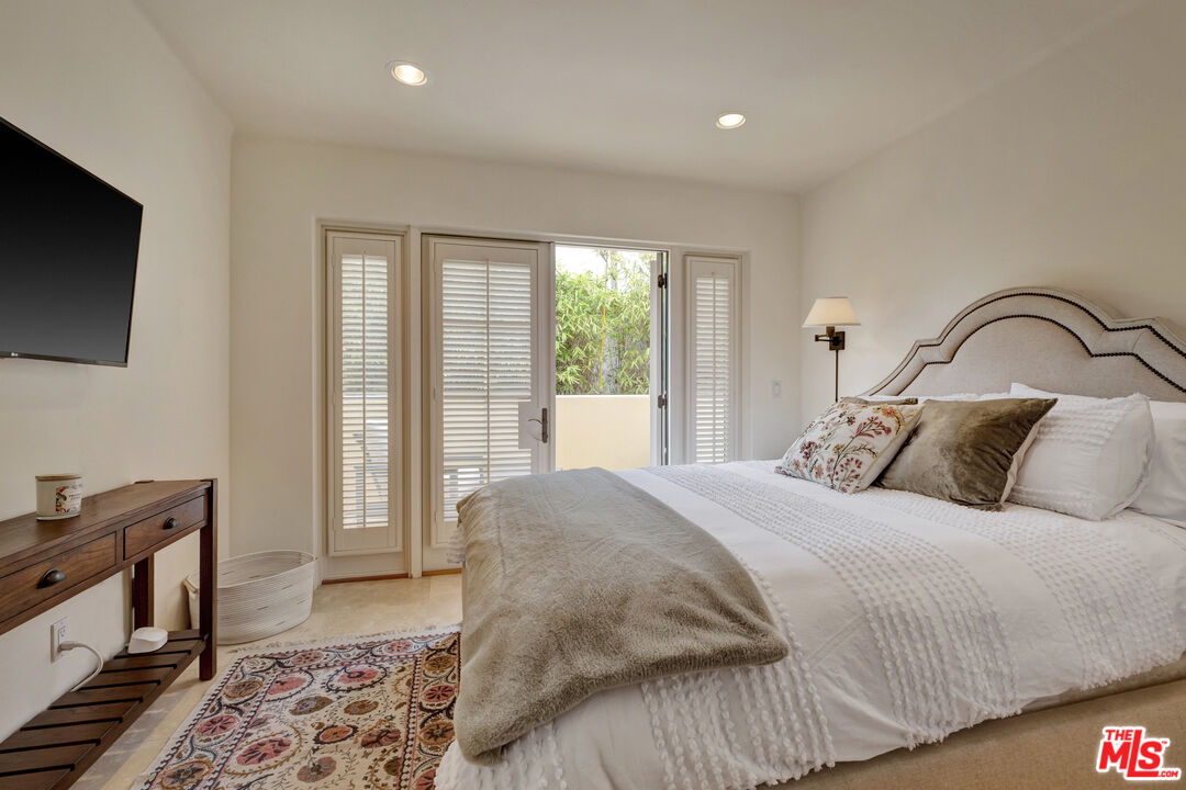 211 Bath Street Santa Barbara, CA 93101 - Photo 9 of 25 a bedroom with a bed and a flat tv screen on dresser