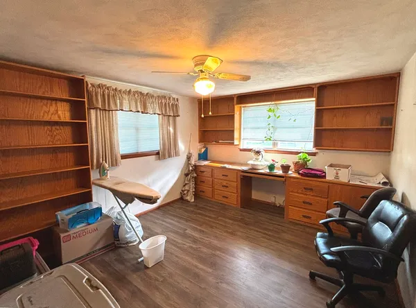 a living room with furniture a flat screen tv and kitchen view