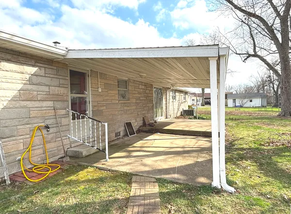 a view of a patio with table and chairs and floor to ceiling window