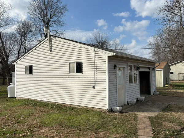 a view of a white house with a large space