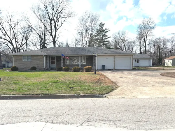 a front view of a house with a yard and trees