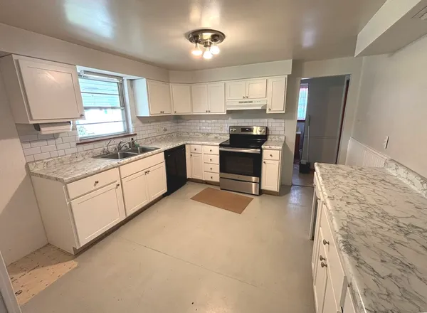 a kitchen with stainless steel appliances granite countertop a stove sink and refrigerator
