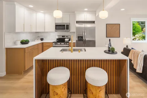 a kitchen that has a lot of cabinets a sink and a refrigerator