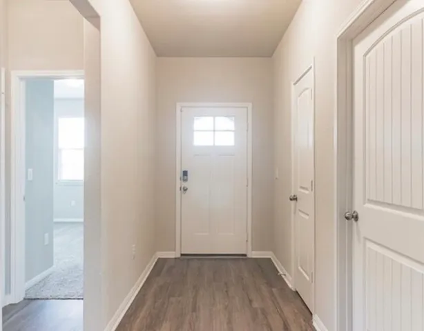 a view of a hallway with wooden floor
