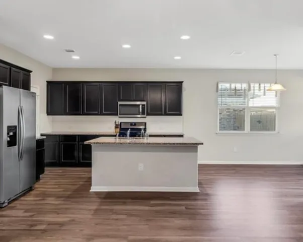 a kitchen with stainless steel appliances granite countertop a stove a sink and a refrigerator