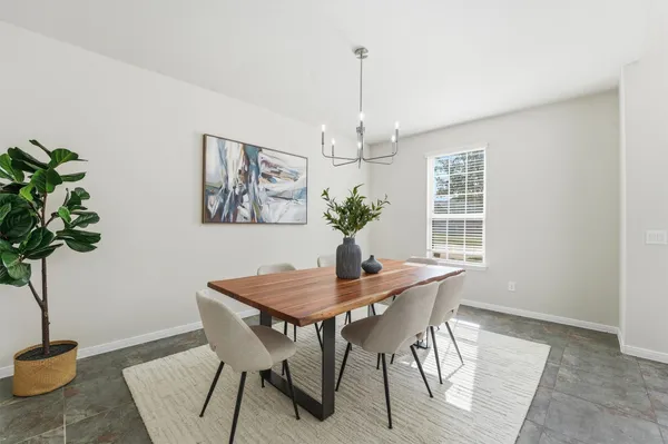 a dining room with furniture potted plants and wooden floor