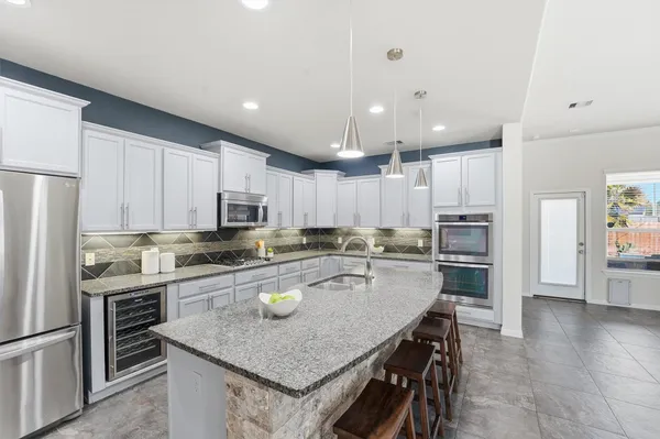 a kitchen with stainless steel appliances granite countertop a sink stove and cabinets