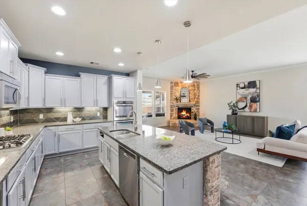 a spacious bedroom with a large bed and a chandelier