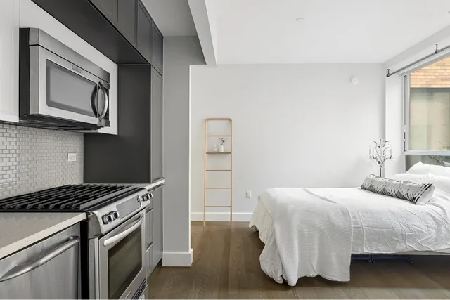 a bedroom with a bed and a microwave