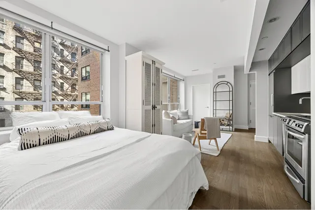 a bedroom with a large bed and a flat tv screen on dresser