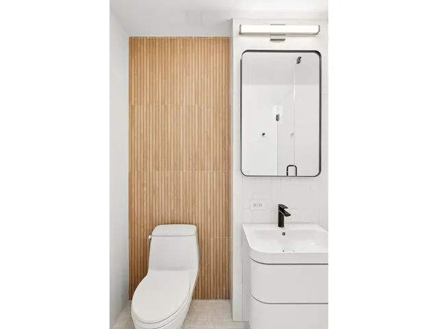 a bathroom with a toilet a sink and mirror