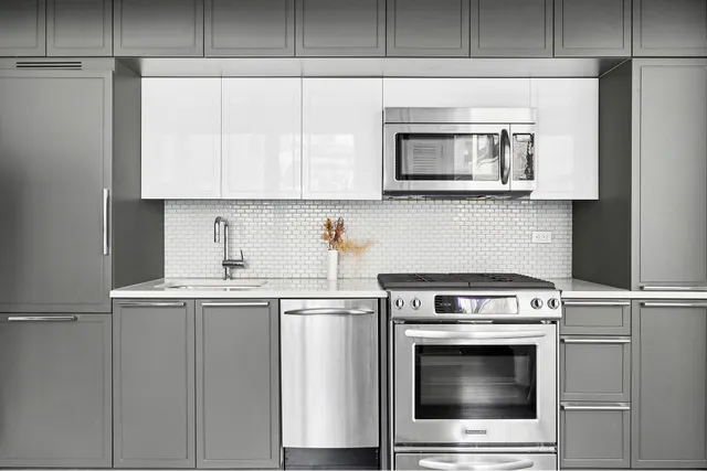 a kitchen with cabinets stainless steel appliances and a sink