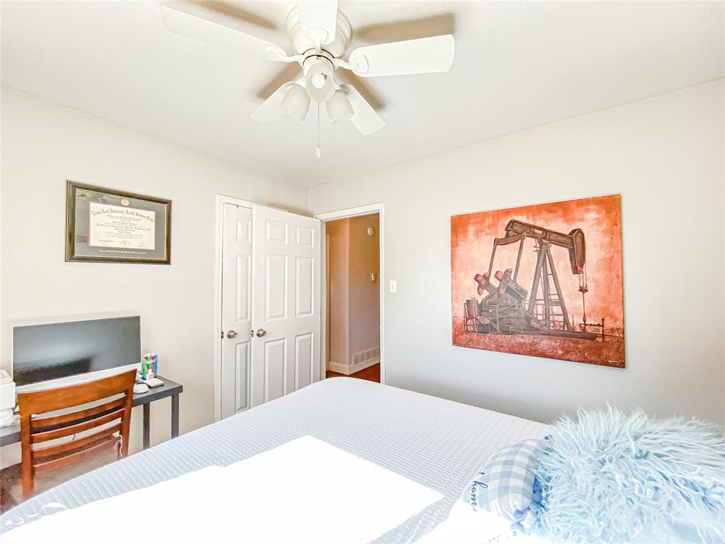 1502 Sunset Street Merkel, TX 79536 - Photo 23 of 35 a bedroom with a bed and a chandelier