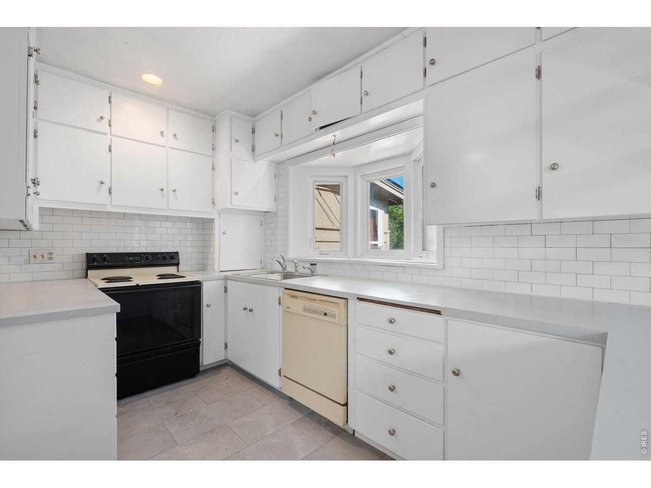 1325 20th Street Greeley, CO 80631 - Photo 2 of 8 a kitchen with granite countertop white cabinets and white appliances