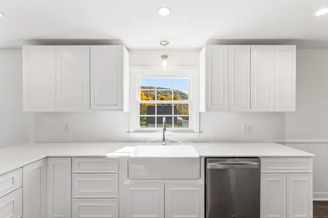 a kitchen with granite countertop a sink cabinets and window